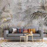 Tapet personalizat leaf cu frunze de palmier si alte plante exotice in tonuri de bej si gri pe un fundal cu aspect de stucada pentru un stil rustic modern gold concrete leaves